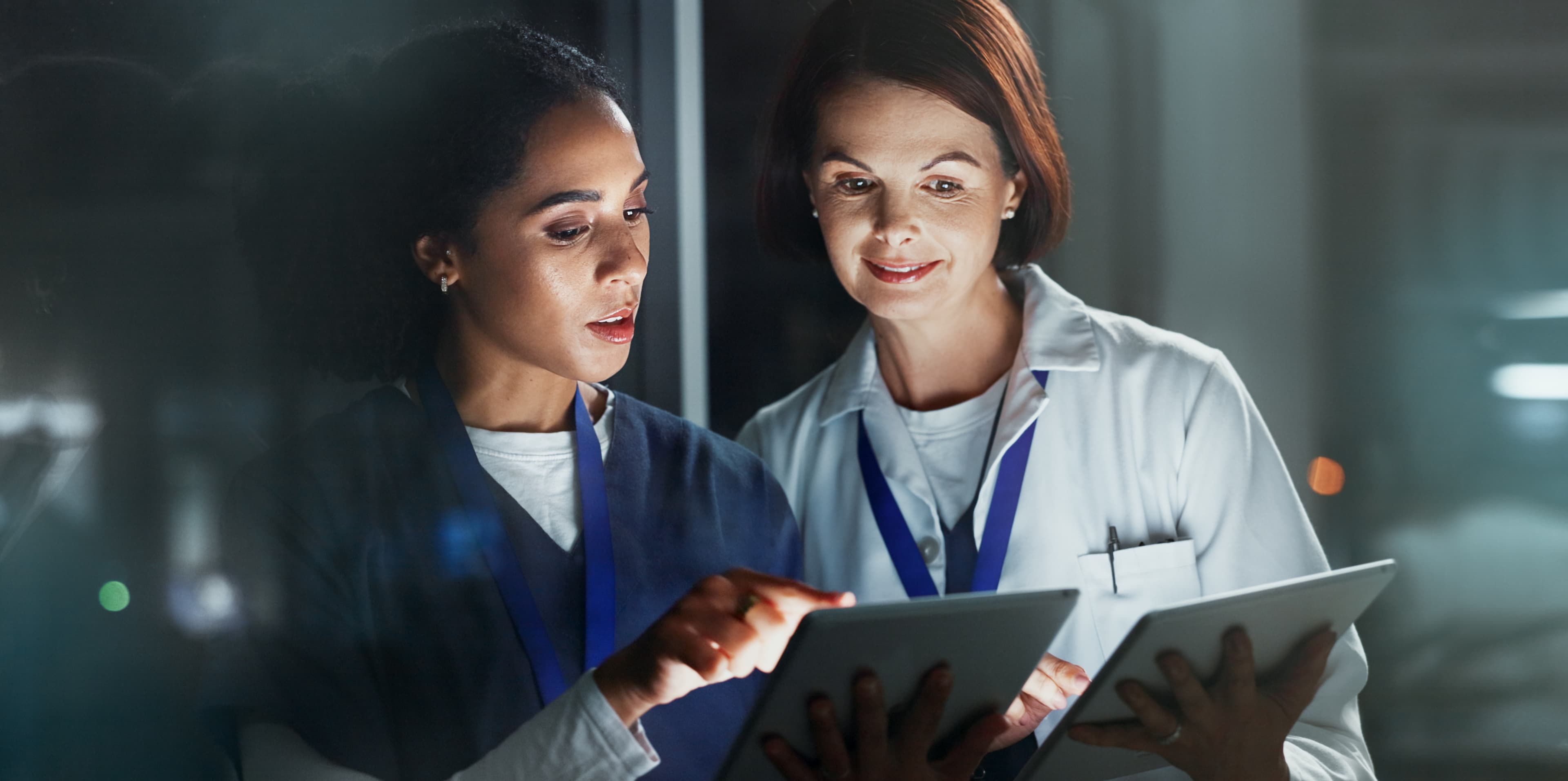 Two clinicians reviewing information together on tablets, representing coached evidence-based practice support for clinical nurses.